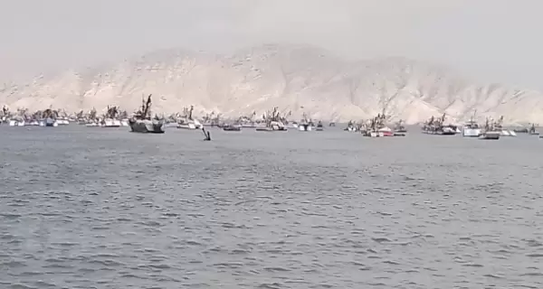Vista desde el mar de Isla Blanca, rodeada de embarcaciones pesqueras frente a las costas de Chimbote.