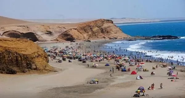 Vista panor�mica de Playa El Colorado en Huacho, con visitantes bajo sombrillas y oleaje suave sobre la arena dorada