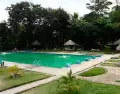 Piscina azul dentro del complejo, acompa�ada de espacios recreativos rodeados de vegetaci�n.