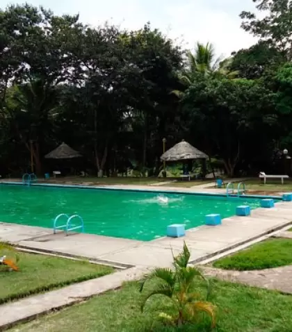 Piscina azul dentro del complejo, acompa�ada de espacios recreativos rodeados de vegetaci�n.