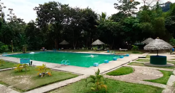 Piscina azul dentro del complejo, acompa�ada de espacios recreativos rodeados de vegetaci�n.