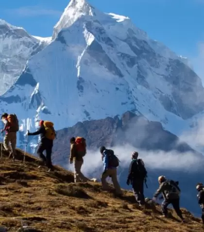 Senderistas caminando por una ruta altoandina de Huaraz, con nevados de la Cordillera Blanca y cielo despejado de julio.