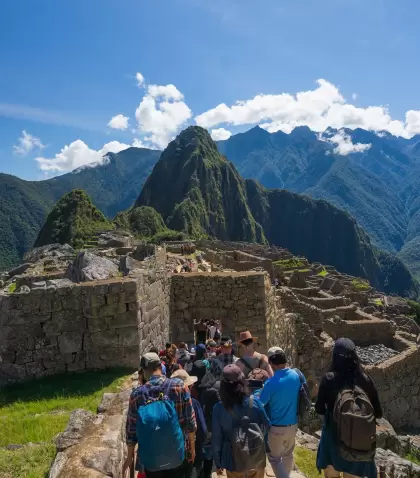 Visitantes recorriendo Machu Picchu en temporada seca, con monta�as despejadas y luz de julio.