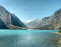 Laguna Llanganuco en julio, con agua turquesa, bosque andino y nevados de la Cordillera Blanca.
