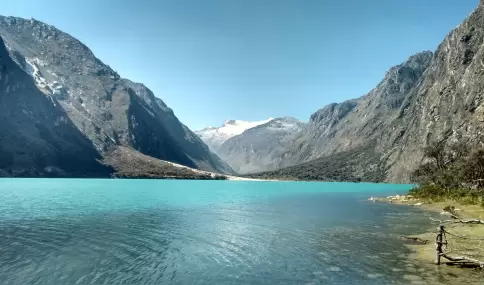 Laguna Llanganuco en julio, con agua turquesa, bosque andino y nevados de la Cordillera Blanca.