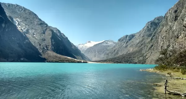 Laguna Llanganuco en julio, con agua turquesa, bosque andino y nevados de la Cordillera Blanca.