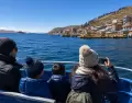 Viajeros abrigados navegando por el Lago Titicaca en julio-