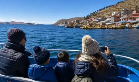 Viajeros abrigados navegando por el Lago Titicaca en julio-