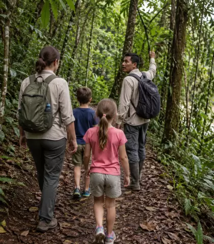 Familia con ni�os caminando por un sendero suave de selva peruana.